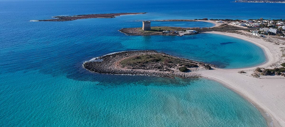 La baia di mare basso turchese di Porto Cesareo vista dall'alto, con la torre costiera